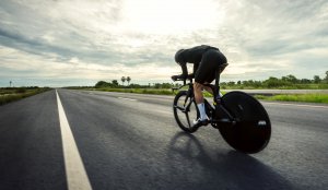 man are cycling time trial bike